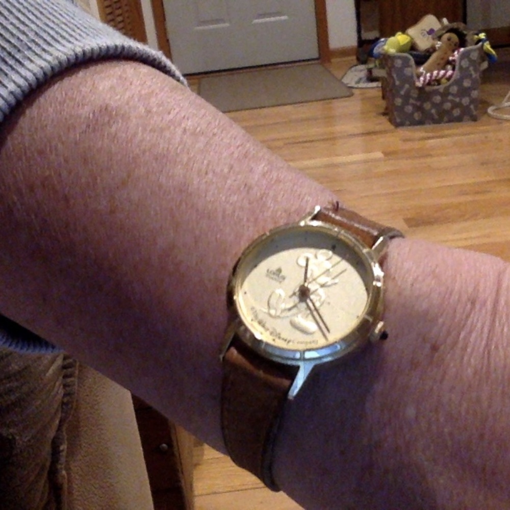 Vintage Mickey Mouse Lotus watch with gold face and leather band.